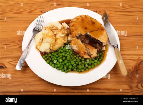 Steak pie, mashed potatoes peas and gravy Stock Photo - Alamy