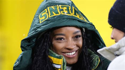 Simone Biles’s Cozy Packers Game Day Look Includes a Blue Puffer Jacket ...