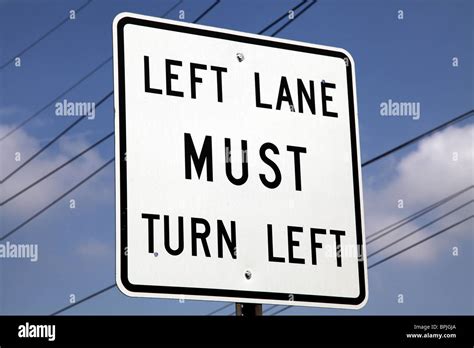 Left Lane MUST turn Left. American road sign Stock Photo - Alamy