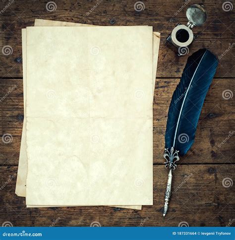 Old Quill Pen, and Old Paper Blank Sheet and Vintage Inkwell on Wooden Desk in the Old Office ...