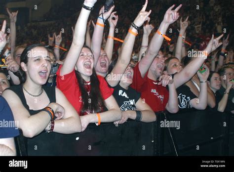 Front row concert fans are shown with their arms in the air during the ...