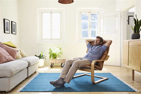 Man relaxing at home sitting in arm chair stock photo