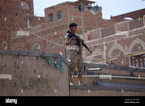 A Shiite fighter, known as a Houthi wearing army uniforms stands guard ...