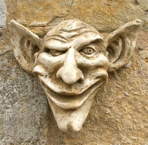 a close up of a face on a stone wall