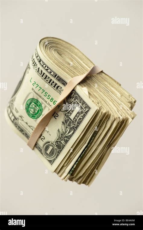 one dollar bills folded in rubber band Stock Photo - Alamy