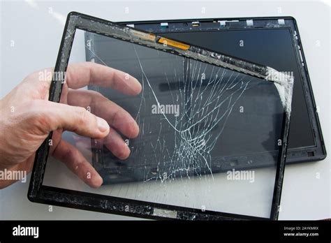 Cracked tablet computer with broken glass touch screen. A technician is ...