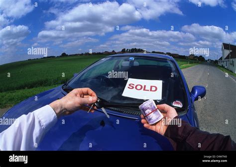 person holding wad of banknotes buying car from salesman holding car keys UK Stock Photo - Alamy