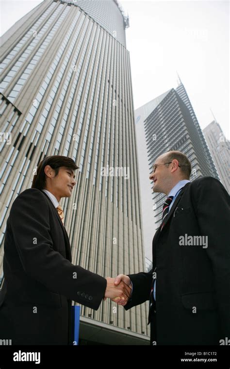 two businessmen from different cultures handshaking in the street in Shanghai,China Stock Photo ...