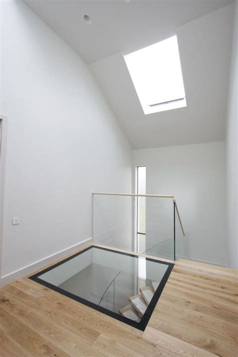 an empty room with a skylight and glass railing on the top floor is shown