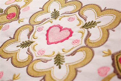 a close up view of a pink and gold flowered design on a white background