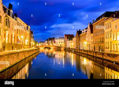 Bruges, Belgium. Night shot of historic medieval buildings along water canal in Brugge, Belgium ...