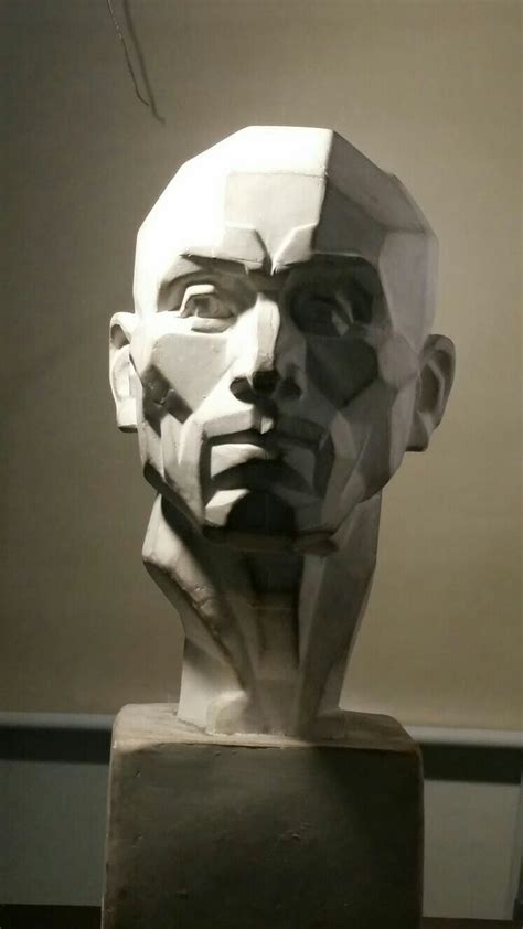 a sculpture of a man's head on display in a room with a wall behind it