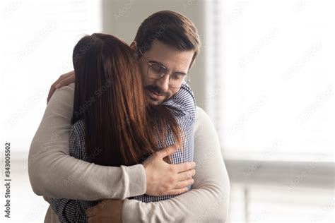 Handsome man embracing woman calms in difficult moment. Husband hugging ...