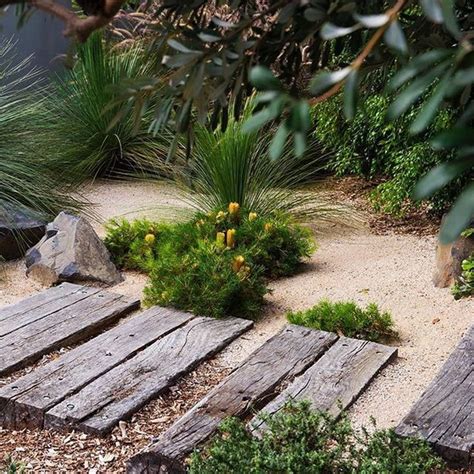 a wooden walkway surrounded by plants and rocks