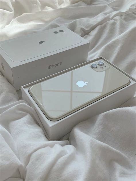 an iphone box sitting on top of a bed next to it's open lid