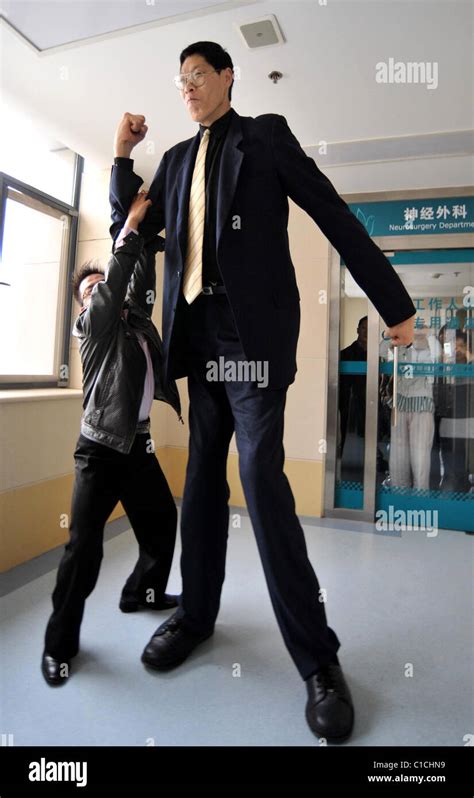 The world's tallest person, Zhang Juncai, (who stands at 7ft 9ins tall) visits Yao Defen (who is ...