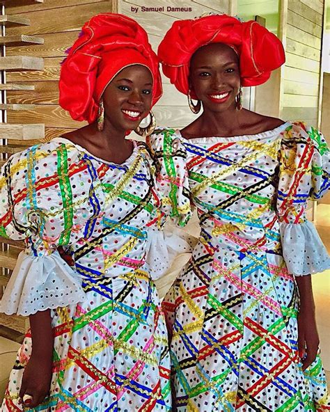 two women dressed in brightly colored clothing standing next to each ...