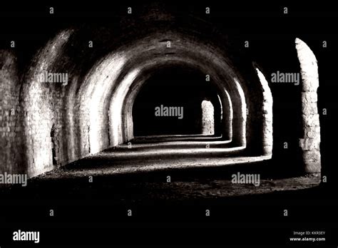 Light shining through round arch shaped niches in a tunnel like cellar ...