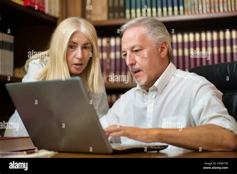 People using a laptop computer in their office Stock Photo - Alamy