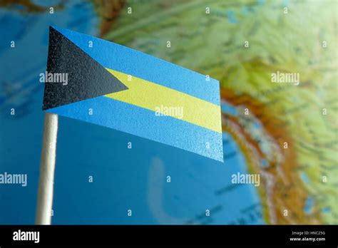 Bahamas flag with a globe map as a background macro Stock Photo - Alamy