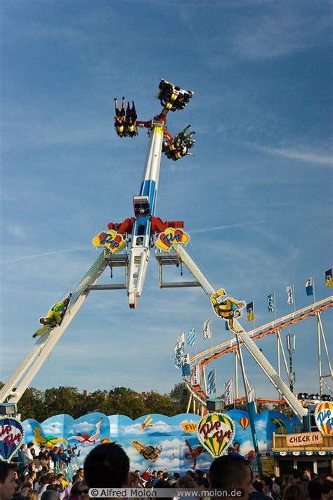 a carnival ride with people riding it in the sky and on top of it is a ...