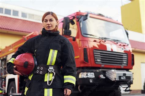 Female firefighter in protective uniform standing near truck Stock ...