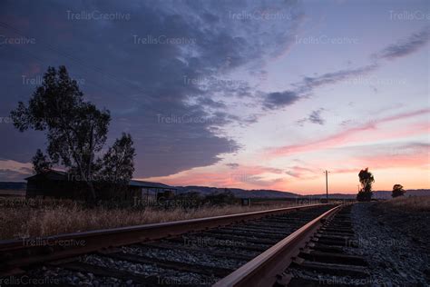 Image: Train tracks leading into the sunset High-Res Stock Photo - TrellisCreative.com