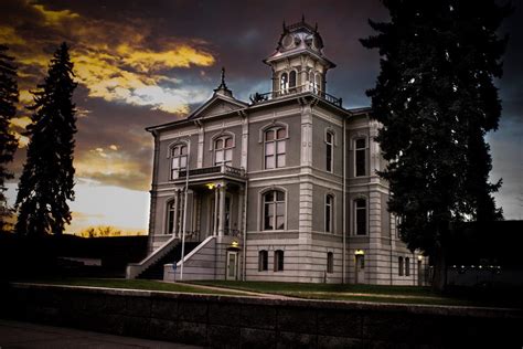 a large white building with a clock tower on the top and stairs leading ...