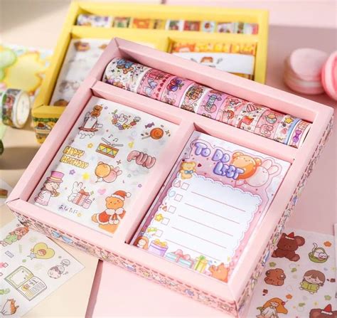 a pink wooden box filled with lots of stickers and writing paper on top ...