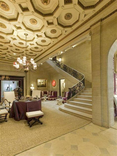 an elegant living room with chandelier and stairs