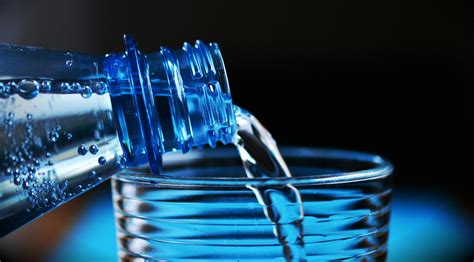 Close-up of Bottle Pouring Water on Glass · Free Stock Photo