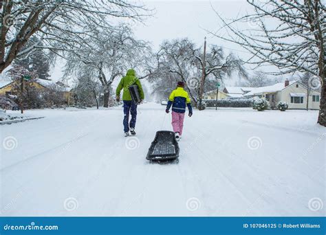 Kids Pulling a Sled Down a Snow Covered Suburban Street. Stock Image - Image of street, clothes ...