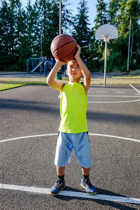 "Asian Kid Shooting Basketball In An Outdoor Basketball Court" by ...