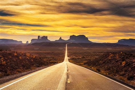 Desert road leading to monument valley at sunset stock photo containing | Nature Stock Photos ...