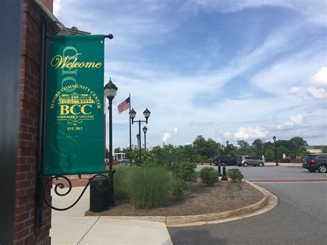 a green welcome sign on the side of a building