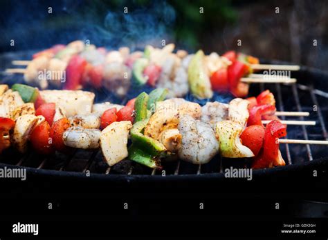 skewers of seafood grilling Stock Photo - Alamy