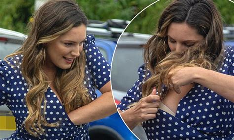 Kelly Brook digs down her dress and exposes her bra