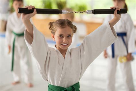 Girl Holding Nunchucks While Practicing Martial Arts