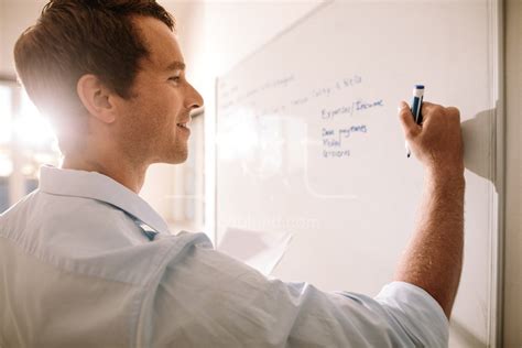 Man writing on whiteboard with marker pen – Jacob Lund Photography Store- premium stock photo