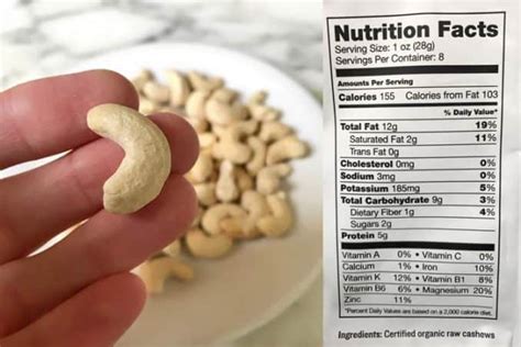 cashew nutrition facts label with photo of hand holding raw organic nut - Superfoodly