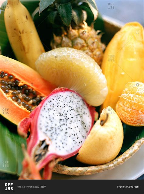 Close-up of different tropical fruits in basket stock photo - OFFSET