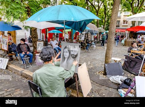 An artist at work sketching a portrait of woman in Place Du Tetre ,a popular Square in ...