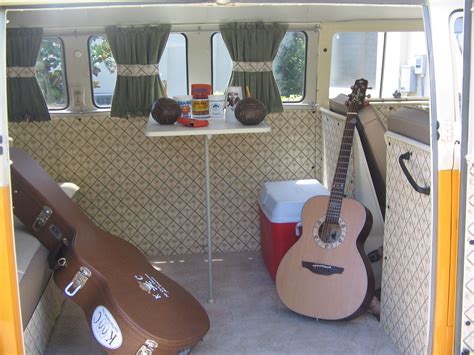 the inside of a bus with guitars and coolers on the floor in front of it