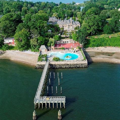 an aerial view of a house with a pool and dock in the middle of it