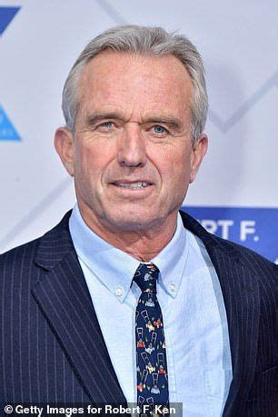 an older man in a suit and tie poses for a photo on the red carpet