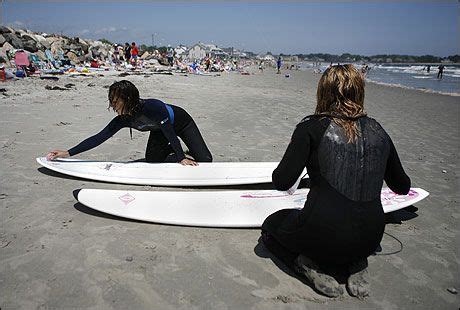 Xochi Calzada (L) and Emma Naworski wax down their surfboards before ...