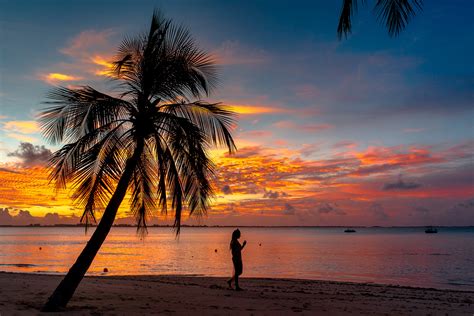 Silhouette of Woman Standing on Beach during Sunset · Free Stock Photo