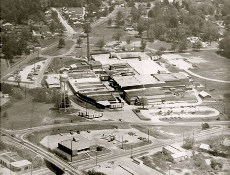 an aerial view of a large industrial area with many buildings and trees in the background