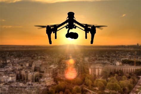 Drone silhouette flying above Paris city panorama