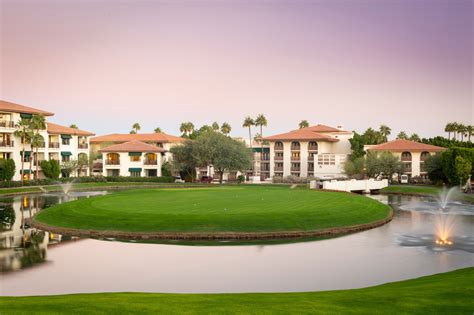 a golf course surrounded by water and buildings